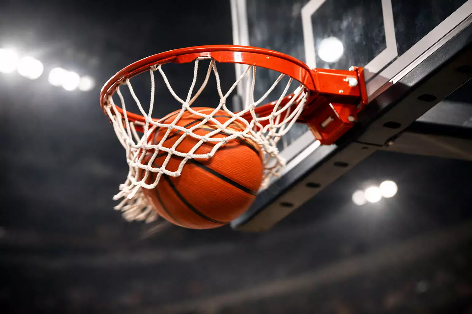 Palla da basket che entra nel canestro durante una partita